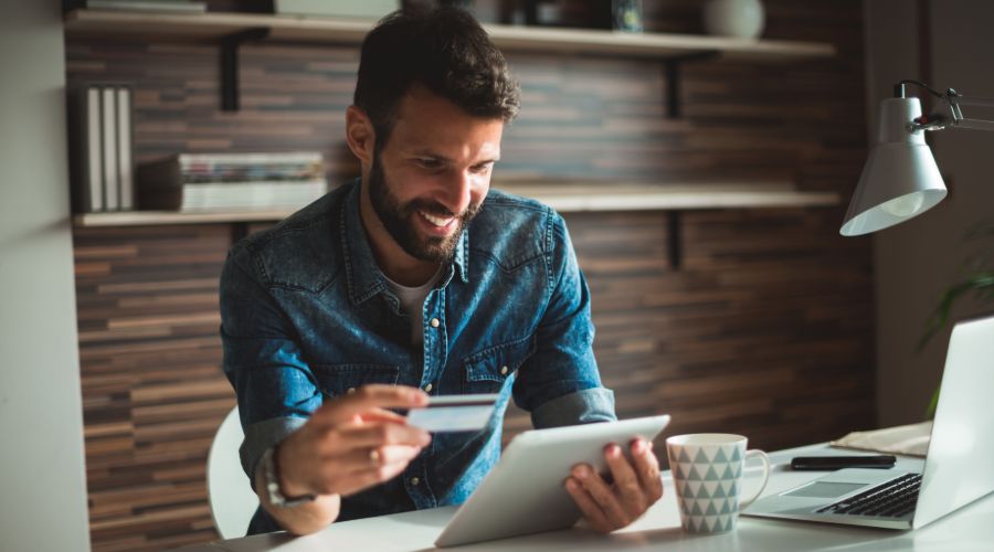 man paying for an expense on a tablet with a credit card