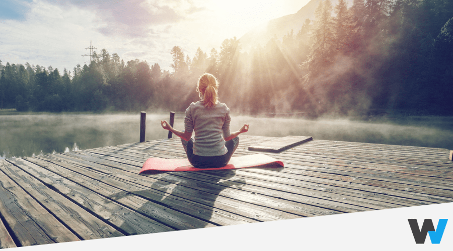 person doing yoga on a dock on the lake