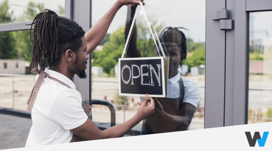 Man hanging Open sign for his local business