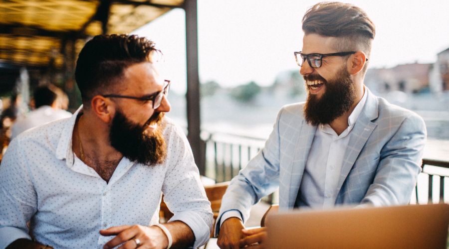 two professional men laughing and working outside