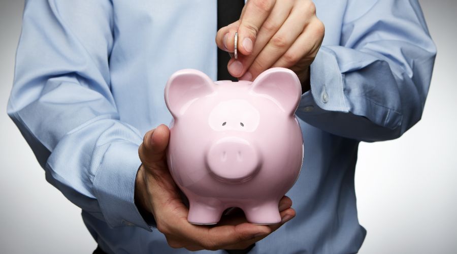 man putting coin in piggy bank