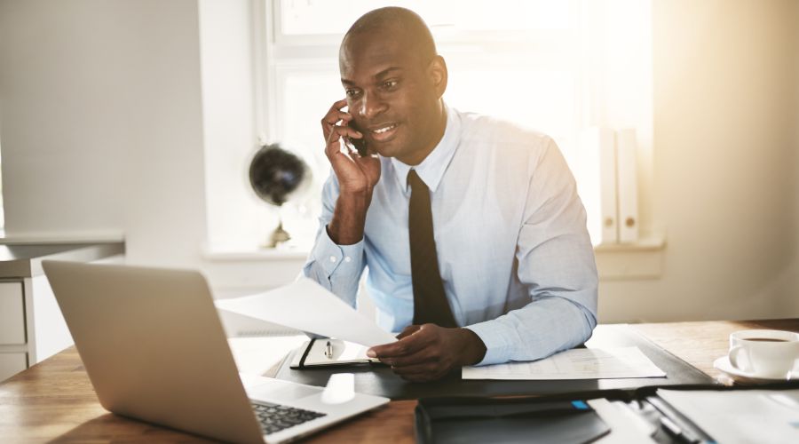 business owner looking at computer while on phone