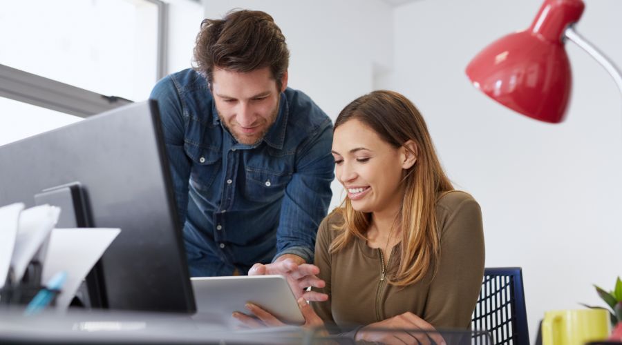 man and woman looking at tablet