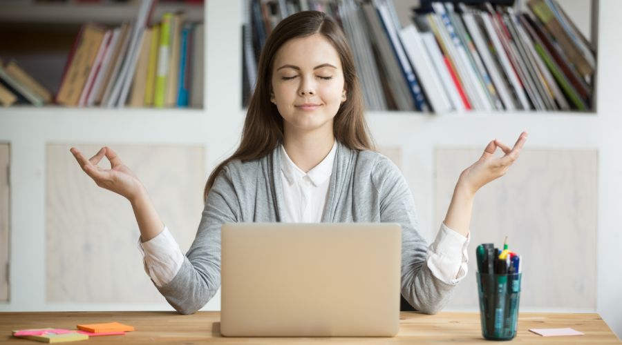 relaxed woman meditating at desk