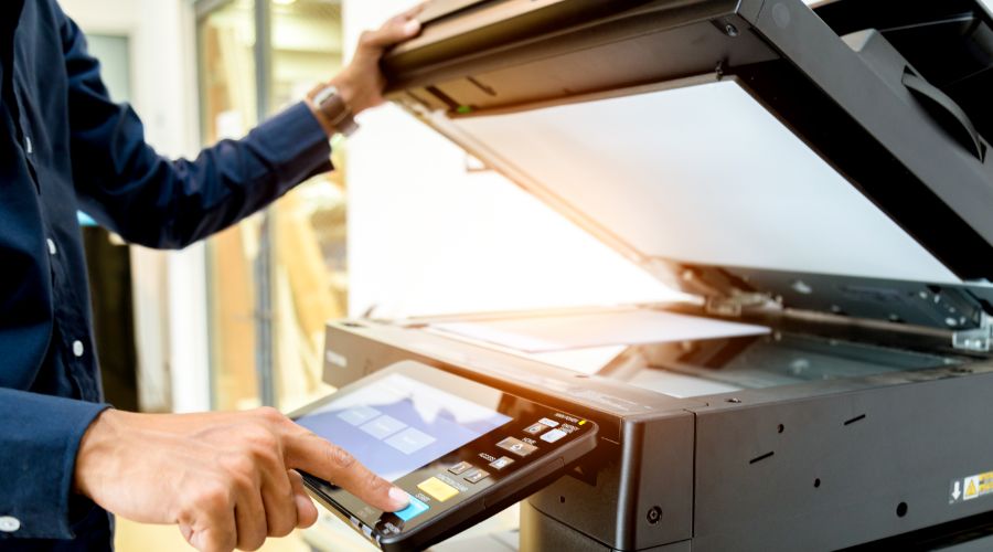 man copying documents on copy machine