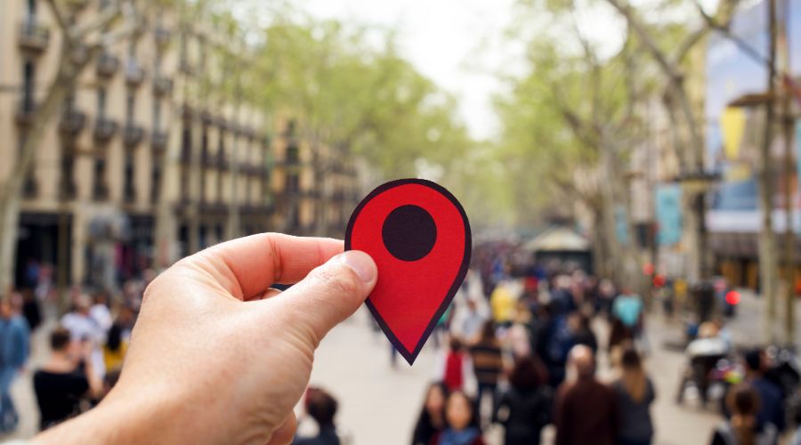 hand holding a location button over city background