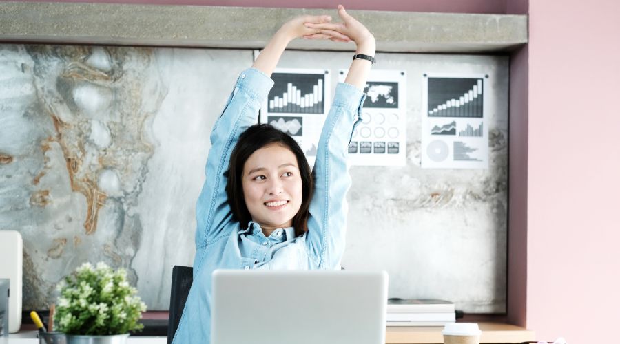 small business owner stretching at desk