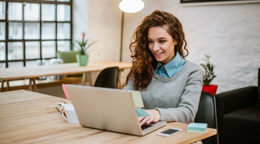 woman runs payroll for her small business on a computer