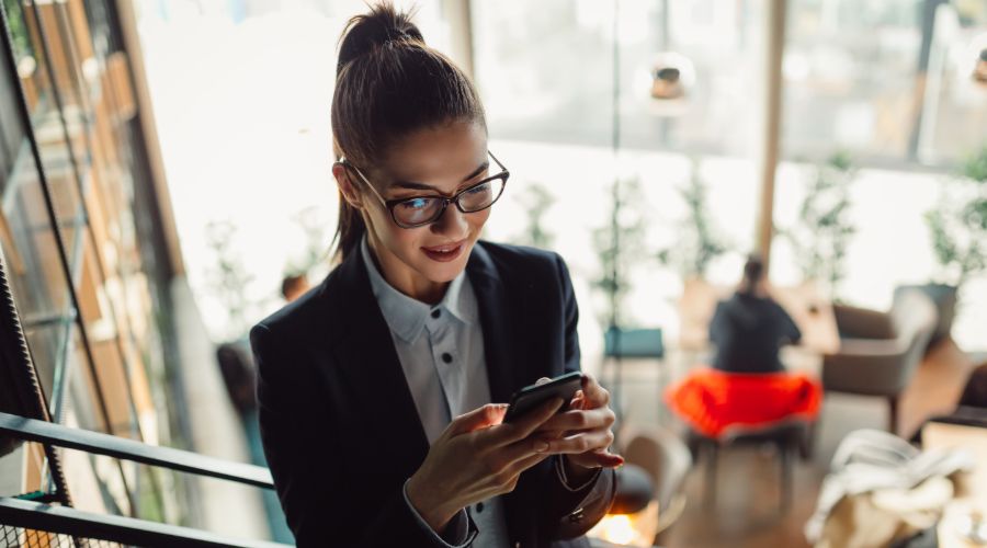 professional woman reviewing HR technology options on her phone