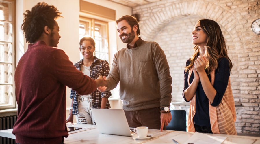 Business owner and employees greeting new hire