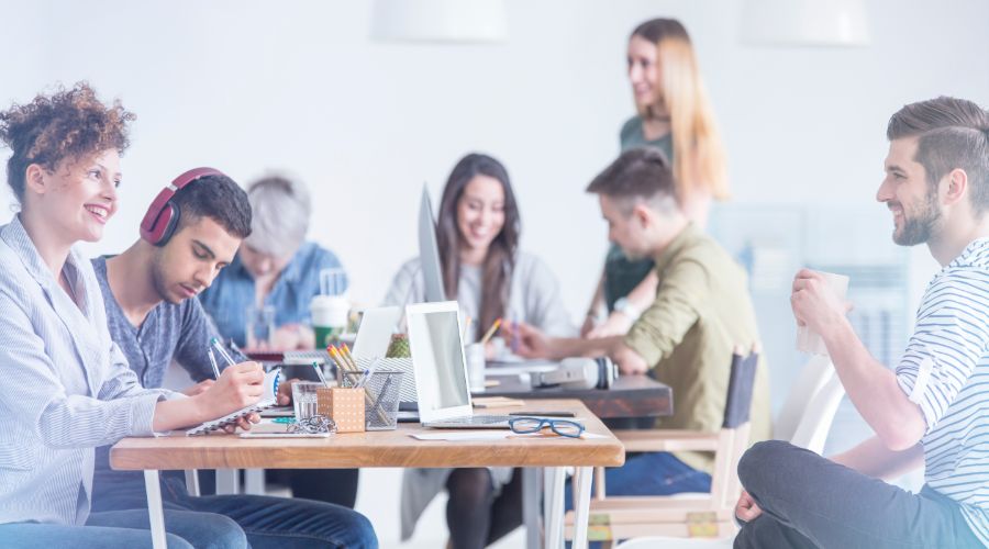 Happy employees sitting around workstations