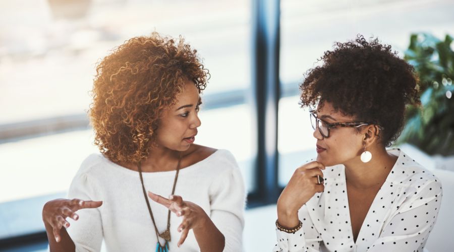 two professional women talking at work