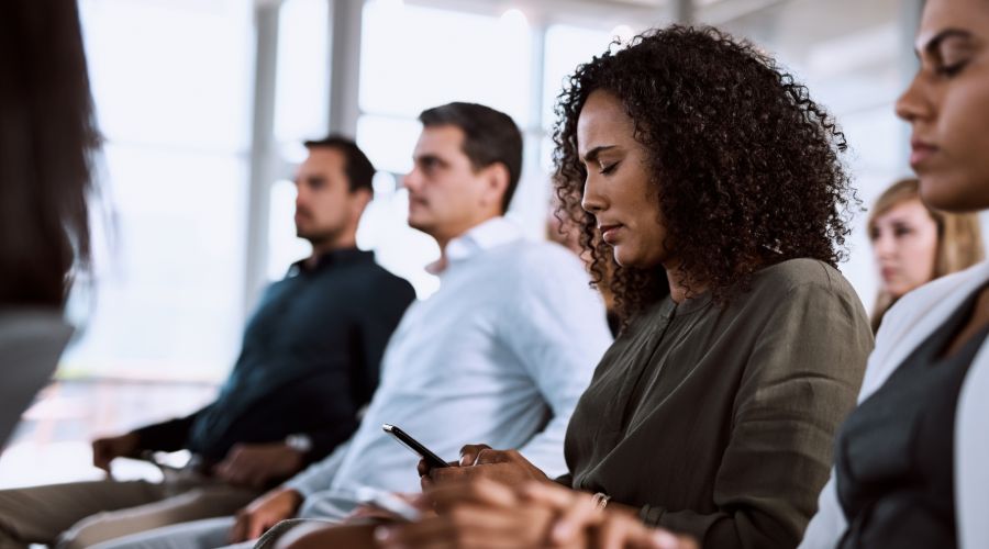 woman looking at her cell phone during a meeting