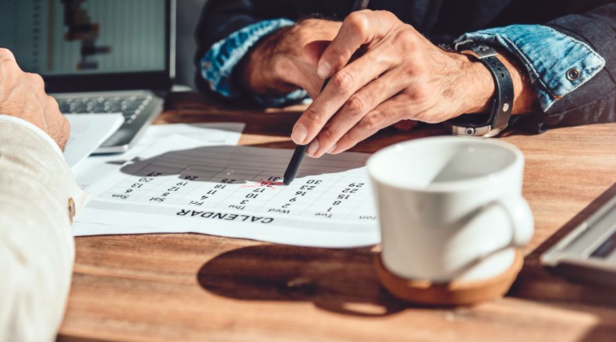 man's handing pointing to a date on the calendar as he asks for time off