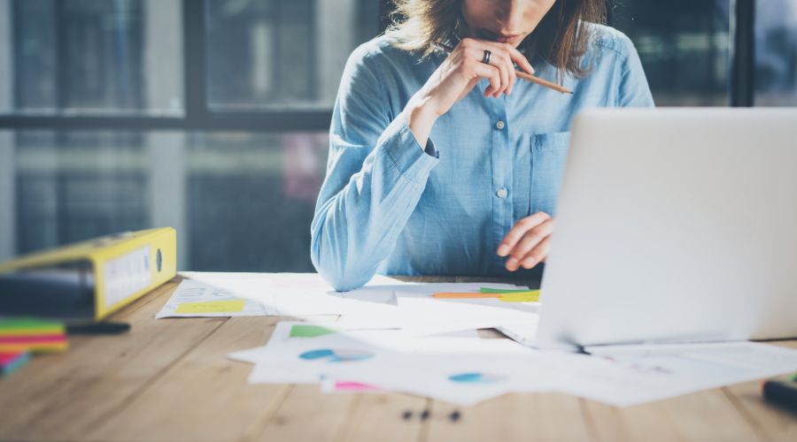 woman reviewing her continuity plan on paper and her computer