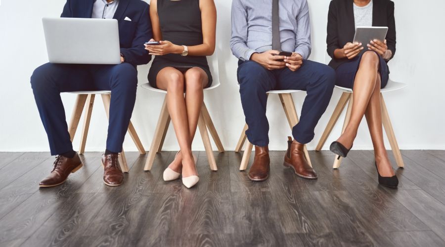 group of professionals with laptops and phones waiting for an interview