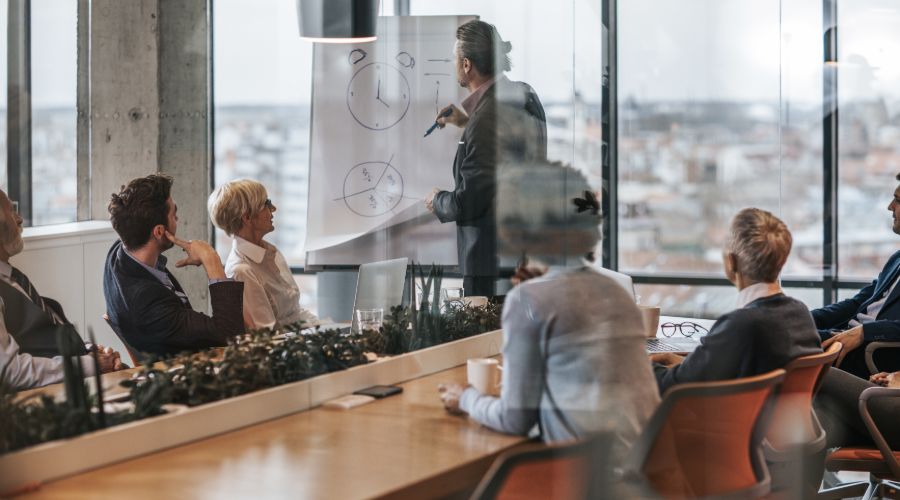 man holding a meeting in his office about time management