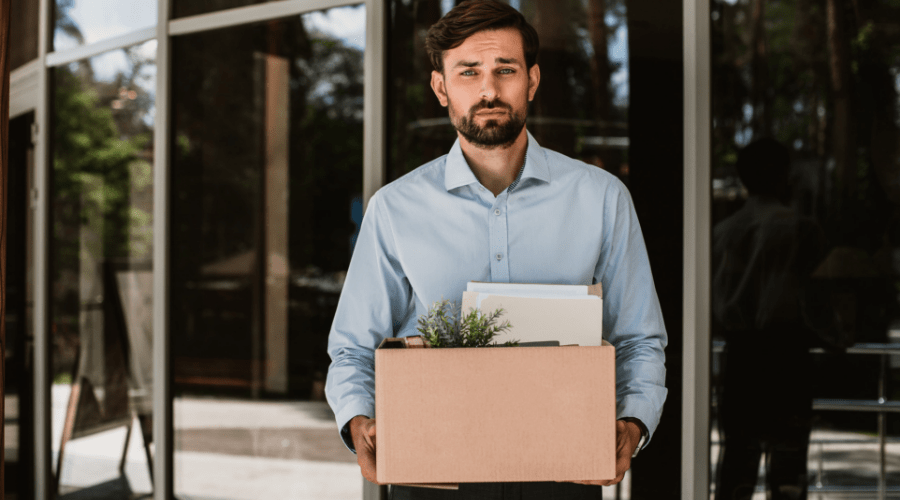 man leaving the office with a box after being laid off