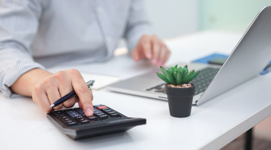 close-up of man pressing calculator to calculate employee’s beginning balances