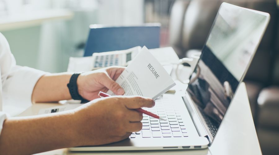 Small business owner reviewing resumes at his desk